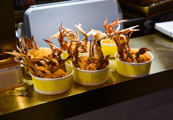 Street food bowls filled with battered crab claws in Shanghai, China. Fried to perfection with a...