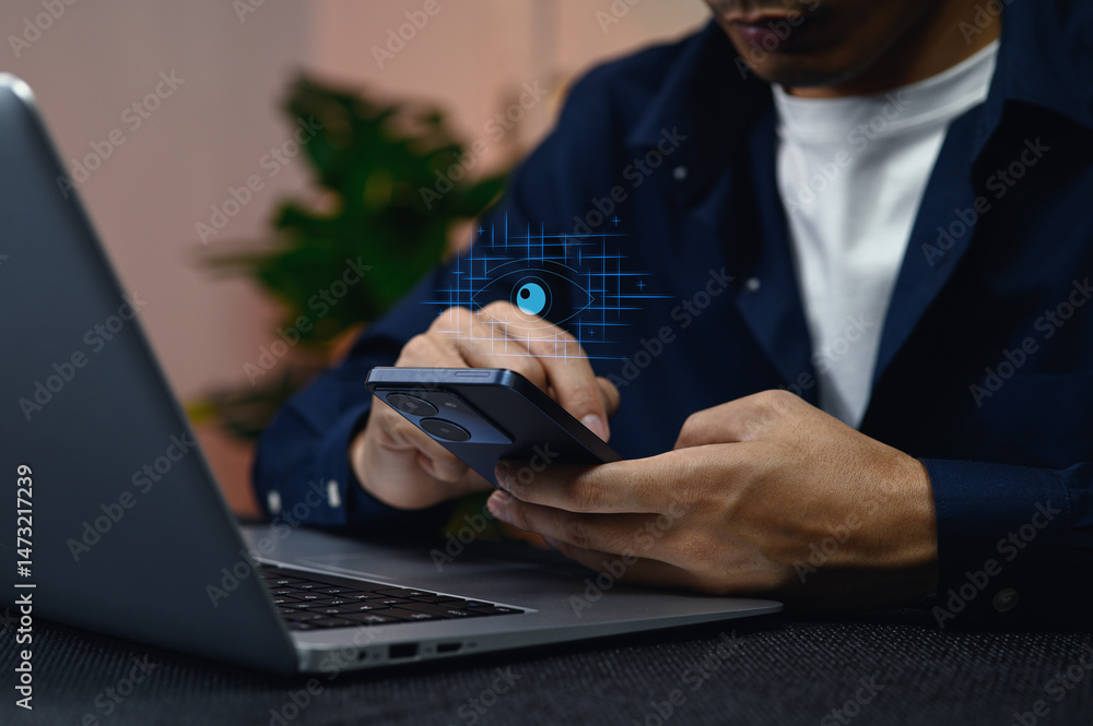 Aufkleber user logging into a system with smartphone and laptop on desk