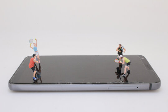 Miniature Tennis Figures on a Smartphone Surface Depicting Digital