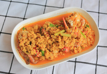 Stir fried crab with curry powder in white plate on the table.