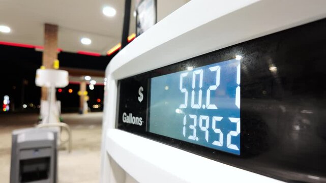 Close up shot of Petrol station with running numbers on gas pump at night time