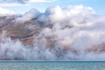 Armenia, Gegharkunik Province. Clouds and mist over Lake Sevan.