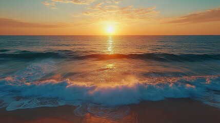 Obraz premium Sun setting over turquoise sea with gentle surf rolling onto beach 