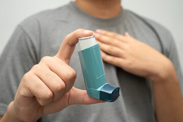 Fototapeta na wymiar Asthma and chronic obstructive pulmonary disease COPD, Asian young man using metered dose inhaler MDI.
