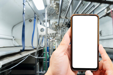 A pair of hands holding a smartphone in an empty subway train captures the essence