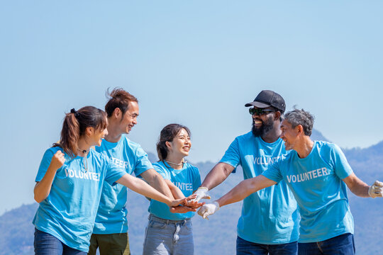 happy diversity conservation volunteers doing hands stack together during a community clean up on sunny day - Powered by Adobe