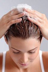 Naklejka premium Woman washing her hair with lather, showing healthy scalp and strands