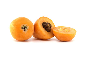 Fresh loquats, Eriobotrya japonica, isolated on a white background, cut open for viewing.