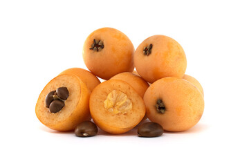 A delightful pile of fresh, ripe loquats, showing both whole and cut sections.