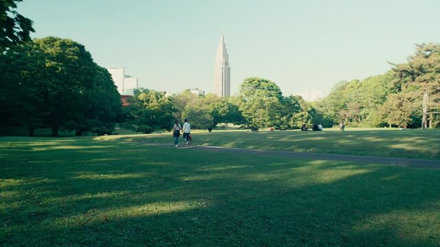 Tokyo Summer Park Scene &ndash; A warm, windy afternoon in Yoyogi Park, with Docomo Tower standing tall in the city skyline behind.
