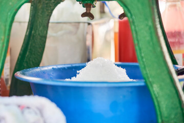 Process of making a raspado, a refreshing dessert traditional as street food in Colombia composed of crushed ice with different sweet flavors and sauces or toppings.