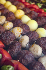 Grilled kebabs with meatballs and vegetables at a barbecue gathering