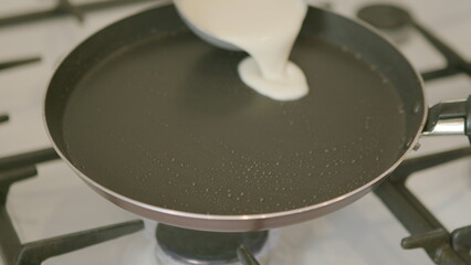 Black NonStick Frying Pan sitting on top of a Gas Stove in a kitchen ready for cooking
