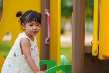 happy toddler girl playing at a outdoor playground in park