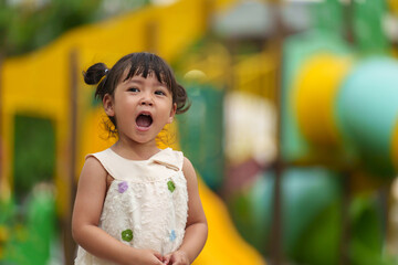 happy toddler girl playing at a outdoor playground in park