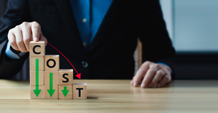 Business concept of cost reduction with stacked wooden blocks forming the word COST, descending arrow, representing expense control, financial optimization, strategic budgeting in corporate planning