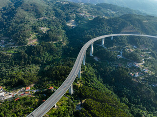 Highway overpass viewed from above, cutting through lush residential countryside in Portugal