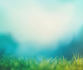 Obraz premium Delicate green grass leading to a soft, hazy backdrop of teal and light blue