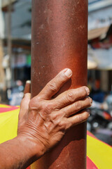 Still life composition showing a man's hand resting calmly on pole