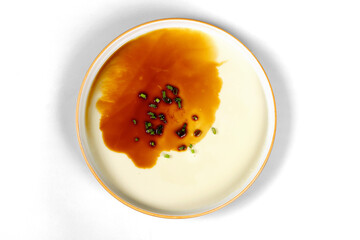 Smooth and sweet steamed egg pudding sprinkled with soy sauce and green onions, white background