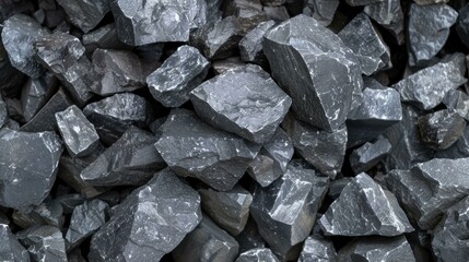 Close-up view of a pile of dark gray, irregularly shaped rocks, exhibiting 