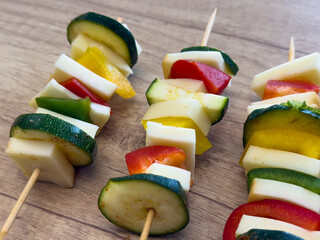 Vegetable skewers with zucchini, bell peppers, and cheese arranged on wooden sticks, ready for...