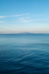 Obraz premium Serene Ocean View with Distant Mountain