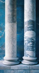 Two antique marble columns against a teal-blue background
