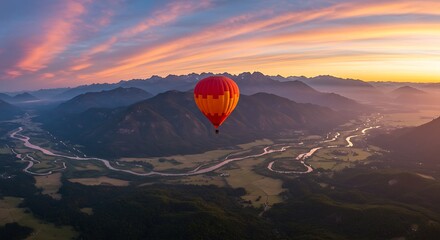 Hot Air Balloon Flying Over Valley at Sunrise with Mountains