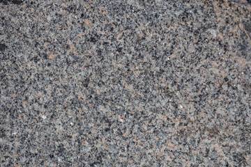 Macro abstract texture background of a multicolor natural granite stone boulder surface
