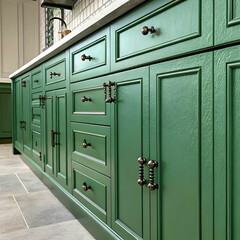large green kitchen cabinet with many handles close