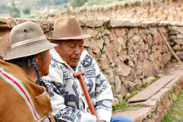 Two old aymara people talking outdoors.