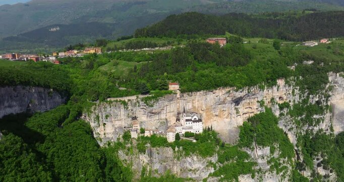 Santuario della Madonna della Corona - Cliffside Sanctuary In Northern Italy, Built Into the Rock Face Of Mount Baldo. aerial pullback shot