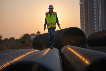 Construction surveyor or engineer working in pipe construction site for inspection detail of...