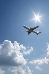 Fototapeta premium sleek modern passenger airplane soaring through clear blue sky surrounded by fluffy white clouds
