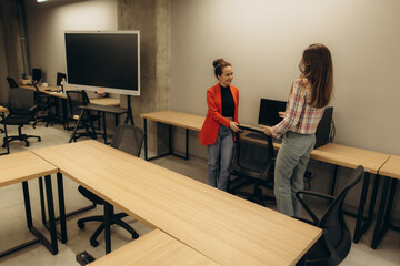 Two Women Discussing in a Modern Office Workspace