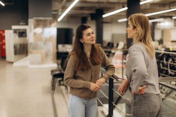 Two Women Talking and Smiling in a Modern Indoor Setting