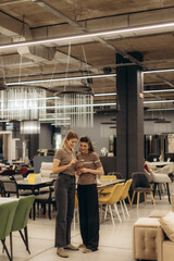 Two Women Shopping in a Modern Furniture Store with Stylish Interior Design
