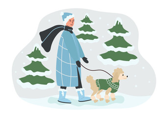 Walking woman with a pet on the street in the park with snow-covered fir trees