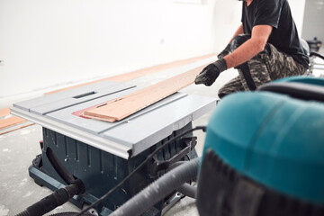Fototapeta premium Professional handyman installing laminate flooring in a new apartment.