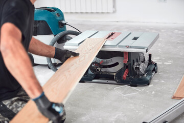 Professional handyman installing laminate flooring in a new apartment.