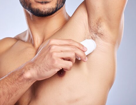 Man applying deodorant to armpit. Hygiene routine for cleanliness and freshness - Powered by Adobe