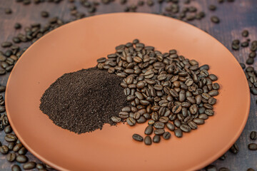 Fresh organic raw coffee beans and ground coffee on plate