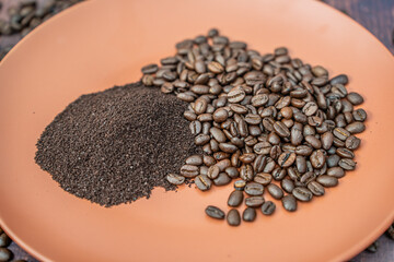 Fresh organic raw coffee beans and ground coffee on plate