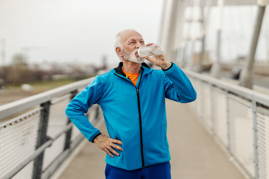 Portrait of thirsty sportsman drinking water and taking a break from urban fitness. - Powered by Adobe
