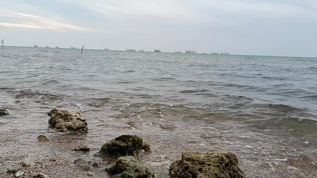 Overcast Coastal View with Active Fishing Fleet on the Horizon
