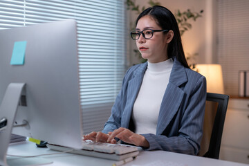 A woman is typing on a computer