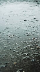 Obraz premium Close-Up View of Wet Sand with Water Droplets and Texture Details