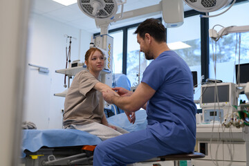 Doctor examining teenage girl's arm during medical checkup.