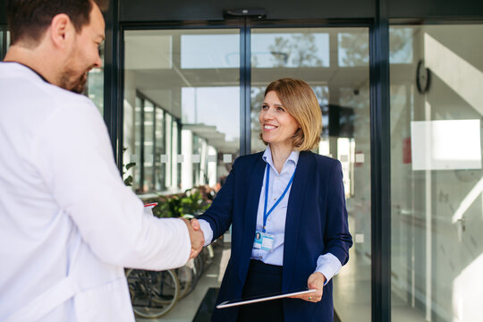 Confident female medical sales representative introducing herself to doctor.